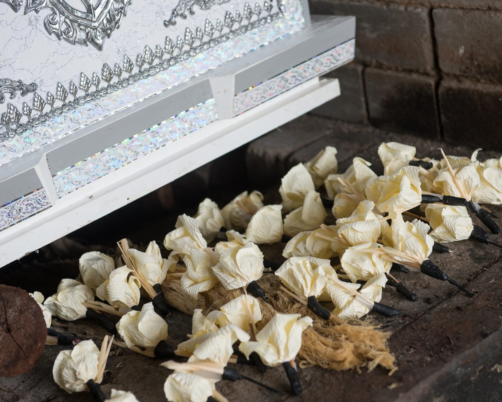 Cream roses gathered beside an ornate casket.